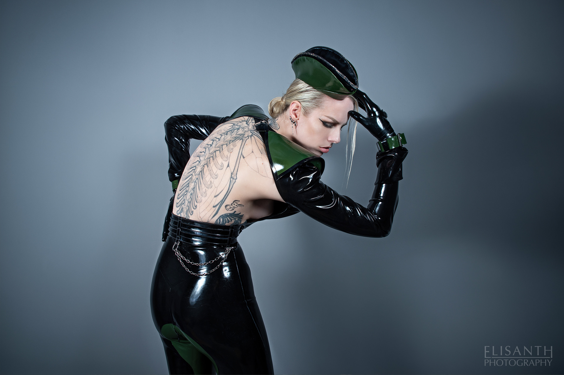 Model wearing a sculptural black and deep green latex ensemble by Ludus Atelier